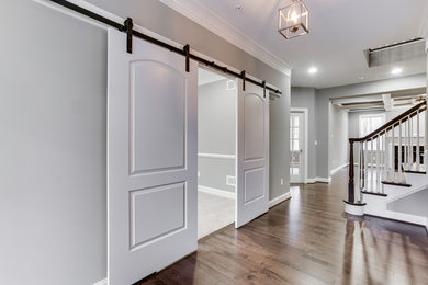 This is an example of a mid-sized transitional hallway in Baltimore with grey walls, dark hardwood floors and brown floor.