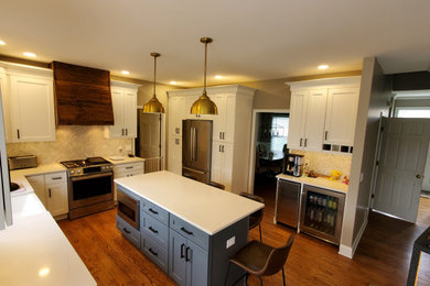 Inspiration for a large modern u-shaped medium tone wood floor and brown floor eat-in kitchen remodel in Chicago with a farmhouse sink, shaker cabinets, white cabinets, marble countertops, white backsplash, marble backsplash, stainless steel appliances, an island and white countertops