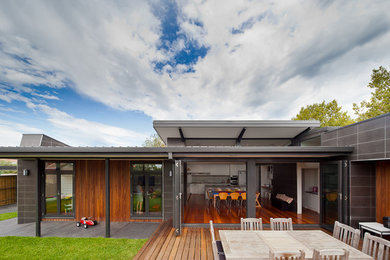 This is an example of a contemporary one-storey grey exterior in Melbourne with mixed siding and a flat roof.