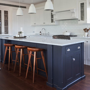 Transitional l-shaped eat-in kitchen in Sydney with an undermount sink, shaker cabinets, blue cabinets, marble benchtops, white splashback, subway tile splashback, stainless steel appliances, medium hardwood floors, with island, brown floor and white benchtop.