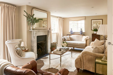 Mid-sized traditional formal enclosed living room in Hertfordshire with beige walls, porcelain floors, a standard fireplace, a stone fireplace surround, a freestanding tv and beige floor.