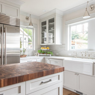 Inspiration for a mid-sized transitional u-shaped separate kitchen in Seattle with a farmhouse sink, recessed-panel cabinets, white cabinets, quartzite benchtops, white splashback, stone slab splashback, stainless steel appliances, light hardwood floors, with island, brown floor, white benchtop and coffered.
