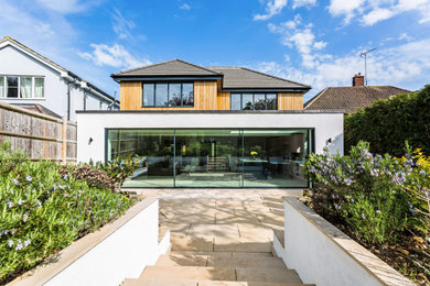 Großes Modernes Haus mit weißer Fassadenfarbe, grauem Dach und Wandpaneelen in Hertfordshire