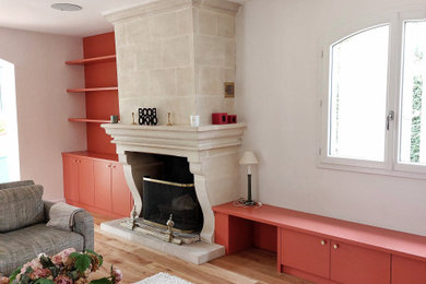 Cette photo montre un salon chic de taille moyenne avec une bibliothèque ou un coin lecture et une cheminée standard.