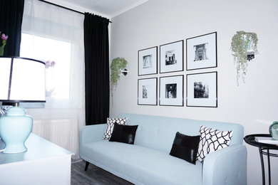 Ejemplo de habitación de invitados ecléctica de tamaño medio con paredes grises, suelo laminado y suelo gris