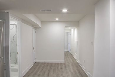 Ejemplo de salón abierto con paredes blancas, suelo vinílico y suelo marrón