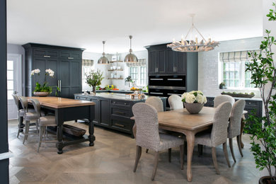 Example of a large classic l-shaped eat-in kitchen design in Philadelphia with recessed-panel cabinets and two islands