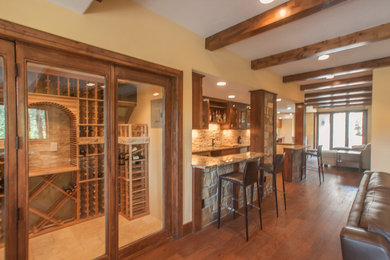 Inspiration for a large rustic walk-out dark wood floor basement remodel in Denver with yellow walls, a standard fireplace and a stone fireplace