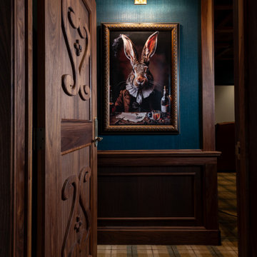 Carved Walnut Door and Framed Art in a Moody Media Room Vignette