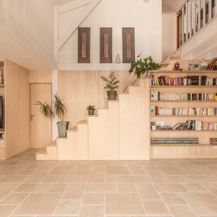 Idee per un grande soggiorno minimal aperto con libreria, pareti multicolore, pavimento in travertino, stufa a legna, parete attrezzata, pavimento beige, travi a vista e pareti in legno