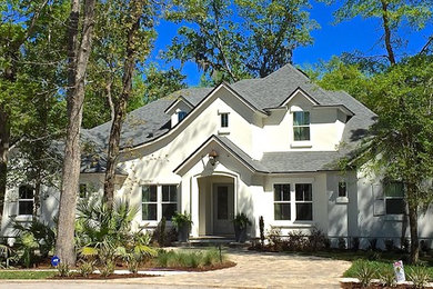 Large elegant white two-story stucco exterior home photo in Jacksonville with a shingle roof