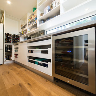Huge beach style kitchen pantry designs - Inspiration for a huge beach style galley medium tone wood floor and brown floor kitchen pantry remodel in Melbourne with an undermount sink, open cabinets, white cabinets, quartz countertops, metallic backsplash, window backsplash, stainless steel appliances and no island