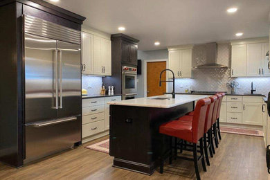 Eat-in kitchen - contemporary galley vinyl floor and brown floor eat-in kitchen idea in DC Metro with stainless steel appliances, an undermount sink, shaker cabinets, white cabinets, quartz countertops, white backsplash, subway tile backsplash, an island and black countertops