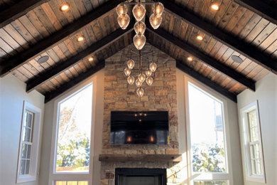 Living room - large eclectic open concept dark wood floor, brown floor and exposed beam living room idea in Chicago with gray walls, a standard fireplace, a stone fireplace and a wall-mounted tv