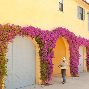 Bild på en medelhavsstil tillbyggd trebils garage och förråd