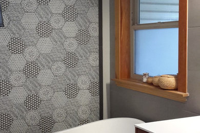 Inspiration for a small modern master gray tile and ceramic tile porcelain tile and black floor bathroom remodel in Other with flat-panel cabinets, medium tone wood cabinets, a one-piece toilet, gray walls, an integrated sink, wood countertops, a hinged shower door and white countertops