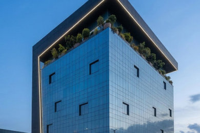 Aménagement d'un grande façade d'immeuble métallique moderne en bardage à clin avec un toit plat, un toit mixte et un toit blanc.