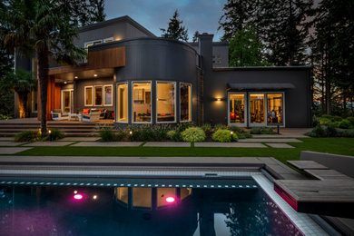 Example of a large trendy gray two-story wood exterior home design in Other