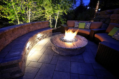 Inspiration for a mid-sized mid-century modern backyard concrete paver patio remodel in Other with a fire pit