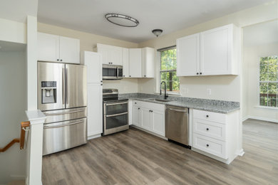 Example of a mid-sized minimalist l-shaped vinyl floor and brown floor eat-in kitchen design in DC Metro with an undermount sink, shaker cabinets, white cabinets, granite countertops, multicolored backsplash, granite backsplash, stainless steel appliances, no island and multicolored countertops