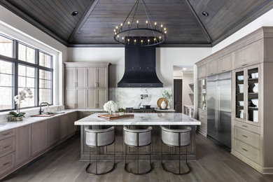 Example of a large transitional dark wood floor and brown floor eat-in kitchen design with quartz countertops, quartz backsplash, stainless steel appliances and an island