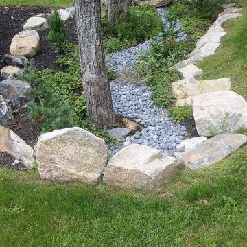 An extensive landscape project with stonewalls, patio, dry river bed & more