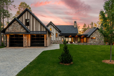 Large rustic brown three-story mixed siding exterior home idea in Minneapolis with a mixed material roof and a black roof