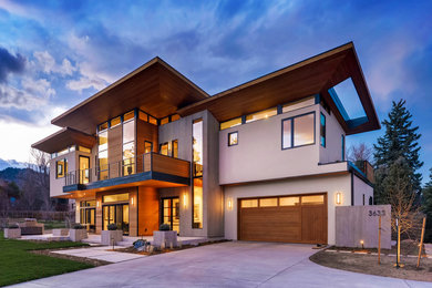 Mid-sized two-storey concrete brown house exterior in Denver with a flat roof and a mixed roof.