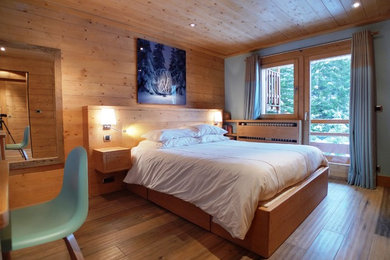 This is an example of a country bedroom in Grenoble with beige walls and light hardwood floors.