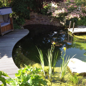 Kleiner Schwimmteich mit Wasserfall, Steg und Stegterrasse