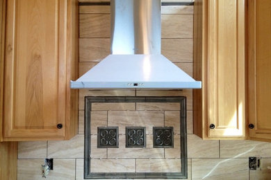 Inspiration for a timeless l-shaped enclosed kitchen remodel in Denver with light wood cabinets, quartz countertops, beige backsplash, porcelain backsplash and stainless steel appliances