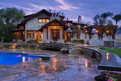 Inspiration for a huge rustic beige stone exterior home remodel in Calgary