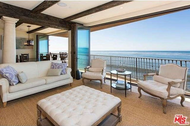 This is an example of a large beach style open concept living room in Los Angeles with white walls and carpet.