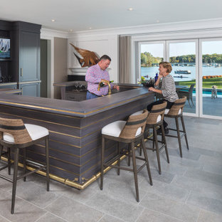 ミネアポリスのビーチスタイルのおしゃれな着席型バー (シェーカースタイル扉のキャビネット、茶色いキャビネット、グレーの床、グレーのキッチンカウンター) の写真