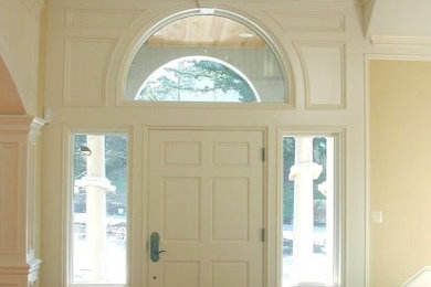 Inspiration for a mid-sized timeless dark wood floor entryway remodel in New York with beige walls and a white front door