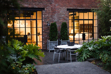 Example of a small urban backyard stone patio design in Other with no cover