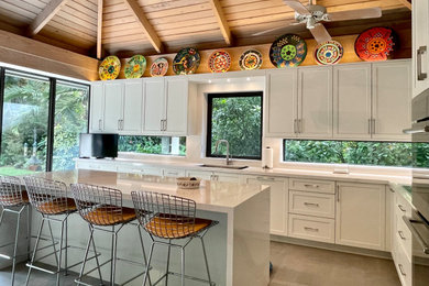 Inspiration for a mid-sized tropical l-shaped porcelain tile, gray floor and exposed beam eat-in kitchen remodel in Miami with a single-bowl sink, shaker cabinets, white cabinets, quartz countertops, multicolored backsplash, quartz backsplash, stainless steel appliances, an island and multicolored countertops