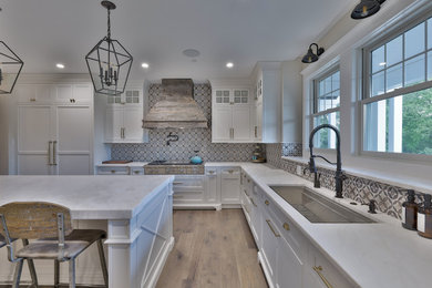 Inspiration for a huge cottage u-shaped dark wood floor and brown floor eat-in kitchen remodel in Philadelphia with an undermount sink, beaded inset cabinets, white cabinets, quartzite countertops, white backsplash, ceramic backsplash, paneled appliances, an island and white countertops