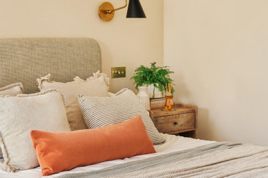 Photo of a large contemporary master bedroom in Other with orange walls, carpet, no fireplace, beige floors and wallpapered walls.