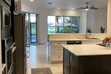Example of a large minimalist l-shaped porcelain tile and white floor eat-in kitchen design in Dallas with an island, shaker cabinets, gray cabinets, marble countertops, white countertops, a single-bowl sink and stainless steel appliances