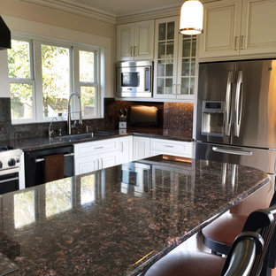 Mid-sized craftsman kitchen pantry designs - Example of a mid-sized arts and crafts u-shaped dark wood floor kitchen pantry design in Sacramento with an undermount sink, shaker cabinets, white cabinets, granite countertops, multicolored backsplash, stone tile backsplash, stainless steel appliances and an island