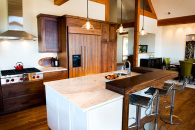 Inspiration for a mid-sized transitional l-shaped open plan kitchen in Denver with an undermount sink, flat-panel cabinets, dark wood cabinets, white splashback, panelled appliances, dark hardwood floors, with island and brown floor.
