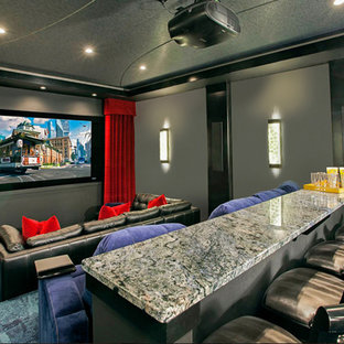 Cette photo montre une grande salle de cinéma fermée avec moquette, un écran de projection et un sol vert.