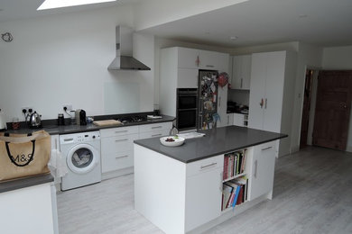 Photo of a modern kitchen in Surrey with an island and grey worktops.