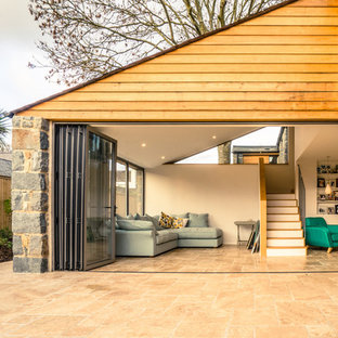 チャネル諸島のラスティックスタイルのおしゃれな二階建ての家 (木材サイディング、ベージュの外壁) の写真