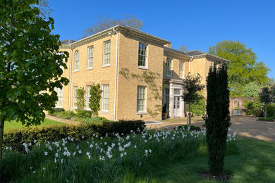 Large country front driveway full sun garden for spring in Hampshire with gravel.