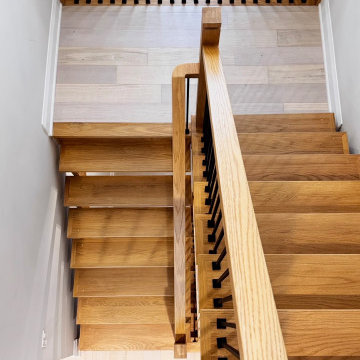 Modern White Oak Open Riser Staircase with Black Metal Balusters
