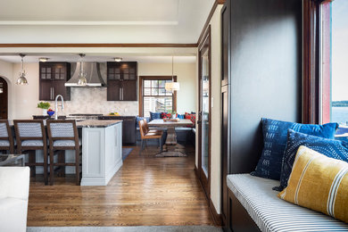 Example of a mid-sized arts and crafts l-shaped dark wood floor and brown floor open concept kitchen design in Seattle with an undermount sink, shaker cabinets, dark wood cabinets, granite countertops, gray backsplash, porcelain backsplash, stainless steel appliances, an island and black countertops