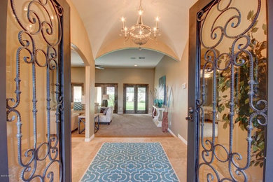 Inspiration for a mid-sized timeless porcelain tile and beige floor entryway remodel in Phoenix with beige walls and a metal front door