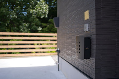 Diseño de fachada de casa negra moderna pequeña de dos plantas con revestimientos combinados
